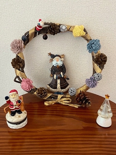 Santa Claus figures gather around a wreath