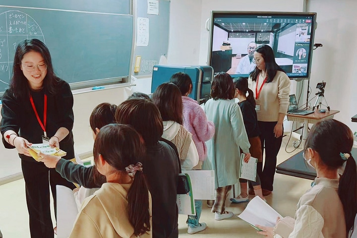 Elementary school third-graders take it in turn to observe samples in the specimen chamber after the class was over