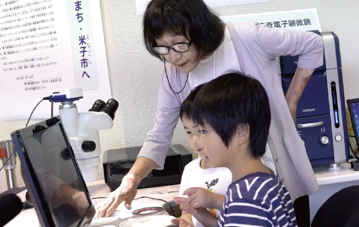 Doctor Inaga guiding students through an observation. Volunteers who have taken a training course offered by members of the project committee may serve as guides in rotation to help children make observations.