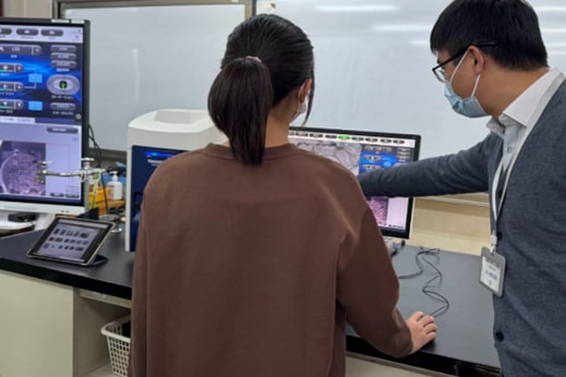 A student representative experiences hands-on observation with microscope